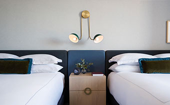 double queen guestroom with bedside lighting